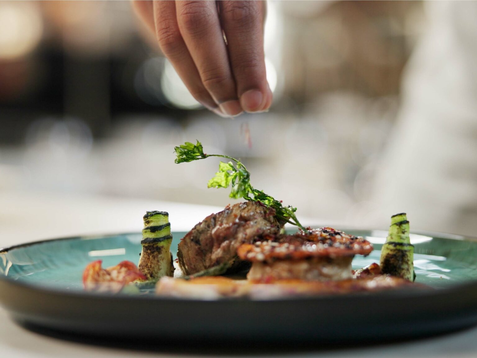 Un chef dando el toque final a un plato emplatado