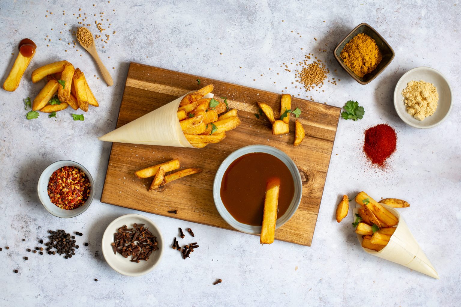 Patatas fritas, salsas y cuencos pequeños con ingredientes para sazonar